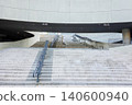 Modern concrete building architecture with wide stone stairs and metal railings 140600940