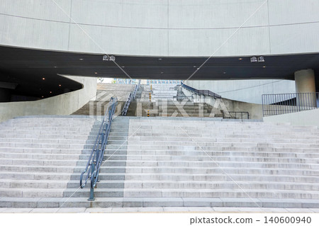 Modern concrete building architecture with wide stone stairs and metal railings Modern concrete building architecture with wide stone stairs and metal railings 140600940