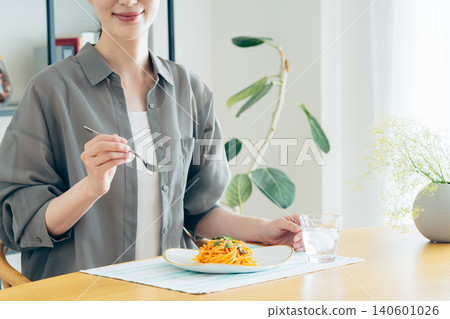 A young woman eating pasta for lunch 140601026