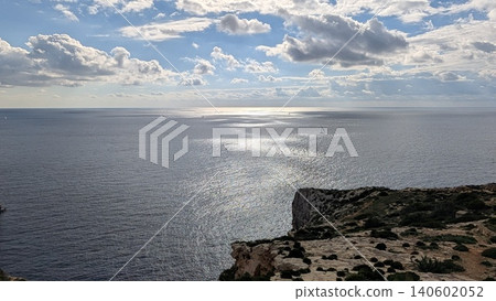 Sunlight reflections on the sea with yacht floating and rocky coast Sunlight reflections on the sea with yacht floating and rocky coast 140602052