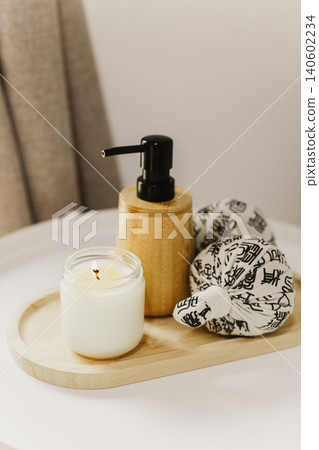 Still life of luxury spa essentials. A bottle with a massage oil and candle on a table. Still life of luxury spa essentials. A bottle with a massage oil and candle on a table. 140602234