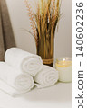 Minimalist still life of luxury spa essentials. White cotton towels with candle on a table. 140602236