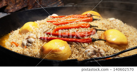 Aromatic pilaf is fried in a cauldron Aromatic pilaf is fried in a cauldron 140602570