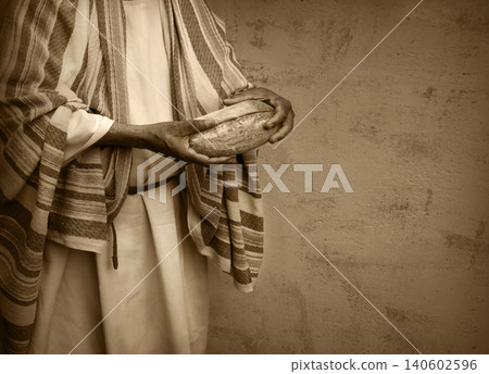 Man's hans holding fresh bread 140602596