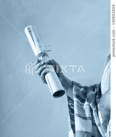 Male hand holding an old scroll Male hand holding an old scroll 140602604