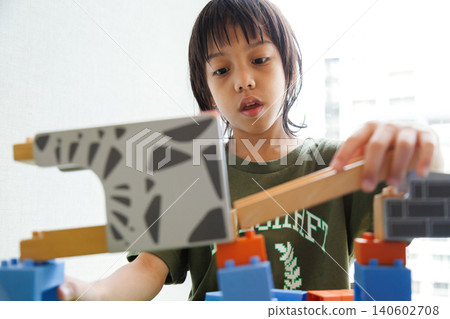 young Asian boy building and playing a creative structure with colorful plastic blocks and wooden toys in the classroom at school or home. Early childhood education and cognitive development concept young Asian boy building and playing a creative structure with colorful plastic blocks and wooden toys in the classroom at school or home. Early childhood education and cognitive development concept 140602708