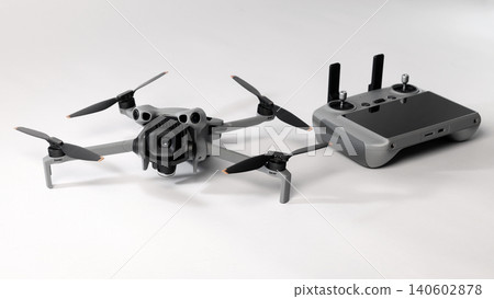 Drone camera. Modern camera drone with remote controller on white background. UAV or Unmanned Aerial Vehical technology for aerial photography videography mapping inspection and recreational flying. Drone camera. Modern camera drone with remote controller on white background. UAV or Unmanned Aerial Vehical technology for aerial photography videography mapping inspection and recreational flying. 140602878