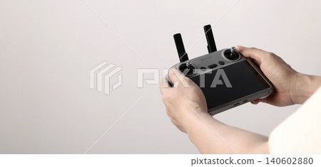 Drone camera. Modern camera drone with remote controller on white background. UAV or Unmanned Aerial Vehical technology for aerial photography videography mapping inspection and recreational flying. Drone camera. Modern camera drone with remote controller on white background. UAV or Unmanned Aerial Vehical technology for aerial photography videography mapping inspection and recreational flying. 140602880