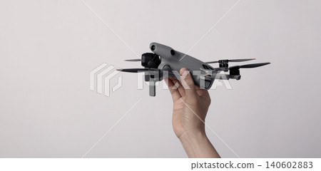 Drone camera. Modern camera drone with remote controller on white background. UAV or Unmanned Aerial Vehical technology for aerial photography videography mapping inspection and recreational flying. Drone camera. Modern camera drone with remote controller on white background. UAV or Unmanned Aerial Vehical technology for aerial photography videography mapping inspection and recreational flying. 140602883