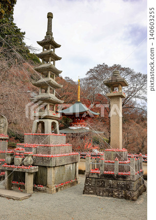 The small stone 5 story pagoda and stone lantern background with The 2-story pagoda at Katsuo-ji Temple in Minoh, Osaka, Japan. Temple of Daruma Dolls. The small stone 5 story pagoda and stone lantern background with The 2-story pagoda at Katsuo-ji Temple in Minoh, Osaka, Japan. Temple of Daruma Dolls. 140603255