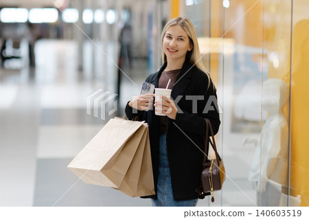Woman enjoying shopping with bags and coffee Woman enjoying shopping with bags and coffee 140603519