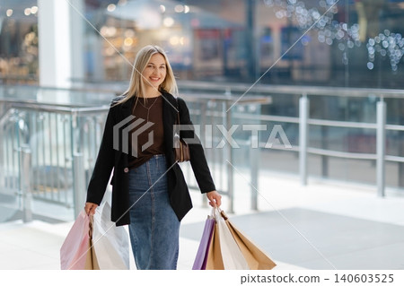 Woman enjoying shopping day carrying colorful bags 140603525