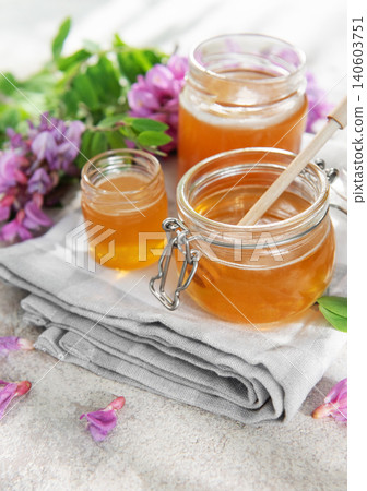 Natural acacia honey jars with blooming flowers 140603751