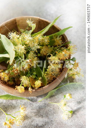 Linden flowers blooming inside wooden bowl for herbal tea Linden flowers blooming inside wooden bowl for herbal tea 140603757