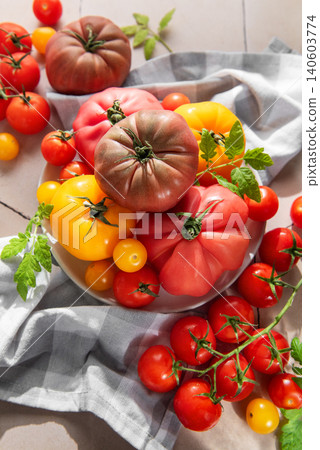 Fresh heirloom tomatoes and cherry tomatoes on tile surface Fresh heirloom tomatoes and cherry tomatoes on tile surface 140603774