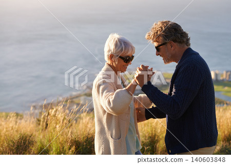 Happy, couple and dance outdoor on holiday, holding hands with love and relax on hill or mountain in Cape Town. Mature, people and embrace with kindness on vacation adventure in nature together Happy, couple and dance outdoor on holiday, holding hands with love and relax on hill or mountain in Cape Town. Mature, people and embrace with kindness on vacation adventure in nature together 140603848