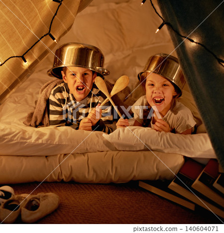Children, siblings and portrait with pot, helmet or spoon in a fort for fantasy, learning or playing at home. Happy family, face or kids on a floor with tent games, development or bonding in a house Children, siblings and portrait with pot, helmet or spoon in a fort for fantasy, learning or playing at home. Happy family, face or kids on a floor with tent games, development or bonding in a house 140604071