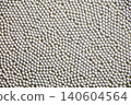 A photograph of a background image covered with small white ceramic balls. 140604564
