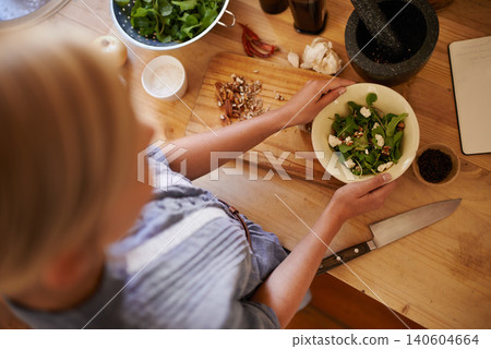 Cooking, woman and salad in a home with green diet, nutrition and healthy food from above. Kitchen, bowl and leaves for organic and vegan lunch with knife and wood board in a house with wellness Cooking, woman and salad in a home with green diet, nutrition and healthy food from above. Kitchen, bowl and leaves for organic and vegan lunch with knife and wood board in a house with wellness 140604664