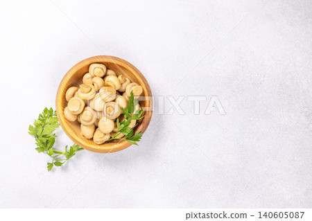 Marinated champignons in wooden bowl with parsley Marinated champignons in wooden bowl with parsley 140605087