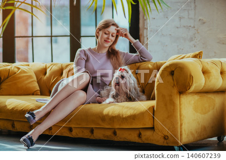 Young elegant woman sitting in sofa with shih tzu dog in a luxurious interior 140607239