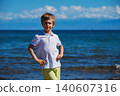 Portrait of happy boy on the shore of lake in summer 140607316