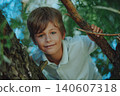 Portrait of a beautiful smiling boy sitting on tree 140607318