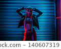 Young woman dancer posing in dark night club interior with neon lights 140607319