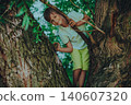 Portrait of beautiful smiling boy sitting on tree 140607320