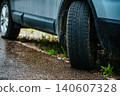 Car wheels standing on the side of the road after rain 140607328