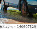 Car wheel standing offroad in a muddy puddle close-up view 140607329