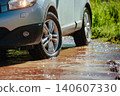 Car wheel standing offroad in a mountain creek close-up view 140607330