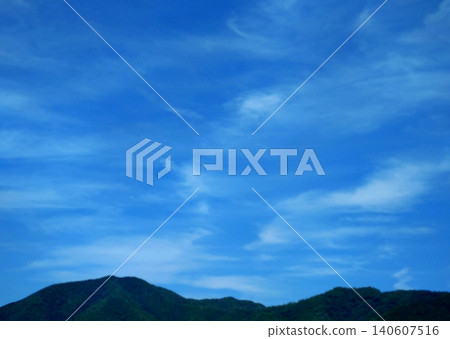 夏日的天空呈現出一幅奇幻的景象：波浪般的雲朵和起伏的山脈交相輝映。 140607516