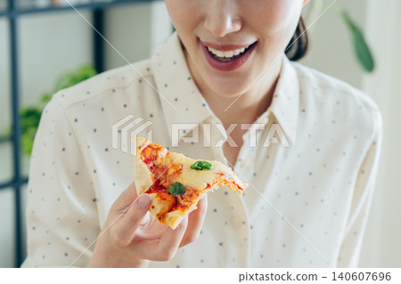 A young woman eating pizza at home A young woman eating pizza at home 140607696