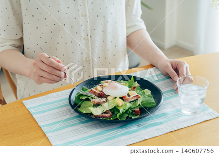 一位年輕女子正在吃凱薩沙拉 一位年輕女子正在吃凱薩沙拉 140607756