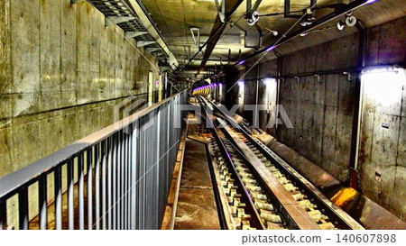 Inside a railway tunnel surrounded by concrete walls: the scenery of the rails and the underground space. Inside a railway tunnel surrounded by concrete walls: the scenery of the rails and the underground space. 140607898