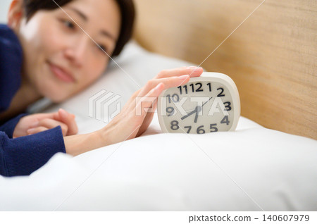 Japanese woman turns off her alarm clock Japanese woman turns off her alarm clock 140607979