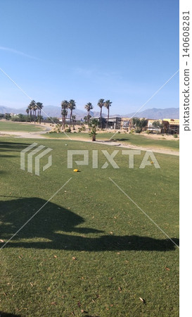 A golf course in La Quinta, California, USA. Palm trees and buildings beyond the well-maintained fairways. 140608281