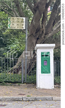Classic green British retropost box and directional signpost next to a large tree Classic green British retropost box and directional signpost next to a large tree 140608353