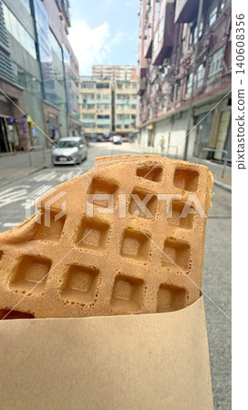 Street food waffle in Hong Kong alleyway with buildings and cars 140608356
