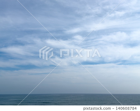 A calm seascape under a pale, cloudy sky. 140608784