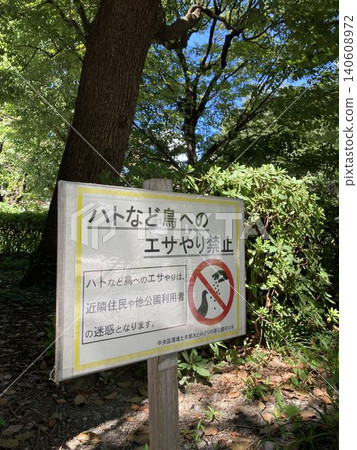 A sign in the park reads, "Feeding pigeons is prohibited." A sign in the park reads, "Feeding pigeons is prohibited." 140608972