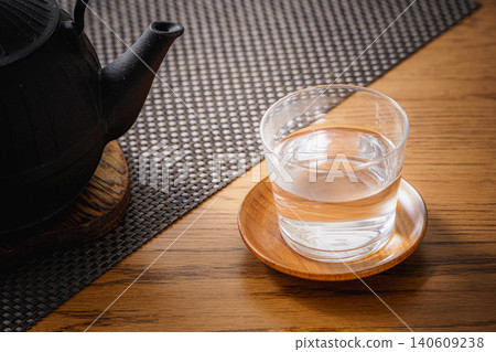 Still life photograph of an iron kettle and hot water. 140609238