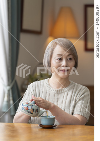 餐廳裡倒茶的老年婦女 餐廳裡倒茶的老年婦女 140609297
