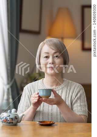 餐廳裡倒茶的老年婦女 餐廳裡倒茶的老年婦女 140609300
