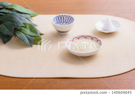 一張靜物照片,描繪了神道祭壇,上面擺放著米飯、一堆鹽巴和神聖的榊樹枝。 一張靜物照片,描繪了神道祭壇,上面擺放著米飯、一堆鹽巴和神聖的榊樹枝。 140609845