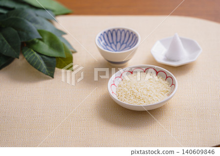 A still-life photograph depicting a Shinto altar with rice, a mound of salt, and sacred branches. A still-life photograph depicting a Shinto altar with rice, a mound of salt, and sacred branches. 140609846
