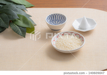 A still-life photograph depicting a Shinto altar with rice, a mound of salt, and sacred branches. A still-life photograph depicting a Shinto altar with rice, a mound of salt, and sacred branches. 140609847