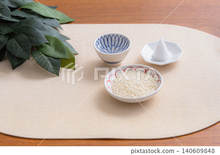 一張靜物照片,描繪了神道祭壇,上面擺放著米飯、一堆鹽巴和神聖的榊樹枝。 一張靜物照片,描繪了神道祭壇,上面擺放著米飯、一堆鹽巴和神聖的榊樹枝。 140609848