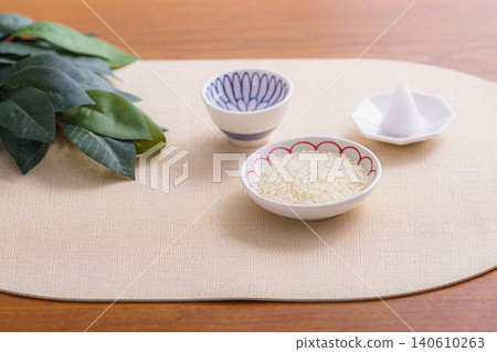 一幅傳統的日本靜物攝影作品,描繪了米粒、一堆鹽和一根神聖的樹枝擺放在一起的場景。 一幅傳統的日本靜物攝影作品,描繪了米粒、一堆鹽和一根神聖的樹枝擺放在一起的場景。 140610263